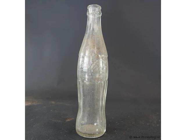 Historische coca-cola glazen fles met het iconische geribbelde 'hobbleskirt'-ontwerp, die sterk lijkt op de doorzichtige coca-cola flessen die tijdens de tweede wereldoorlog door amerikaanse soldaten werden gebruikt - afbeelding 4 van  6