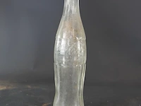 Historische coca-cola glazen fles met het iconische geribbelde 'hobbleskirt'-ontwerp, die sterk lijkt op de doorzichtige coca-cola flessen die tijdens de tweede wereldoorlog door amerikaanse soldaten werden gebruikt - afbeelding 4 van  6