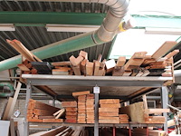 Houten planken, balken en latten in 5 vakken van en op stelling.
