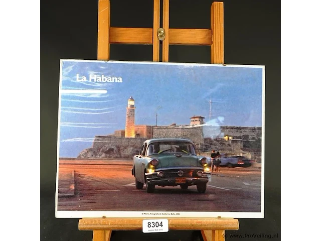 Ingelijste foto of poster getiteld "la habana" met een klassieke amerikaanse auto en de vuurtoren van het castillo de los tres reyes del morro in de achtergrond, gefotografeerd door guillermo bell in 2004 - afbeelding 1 van  5