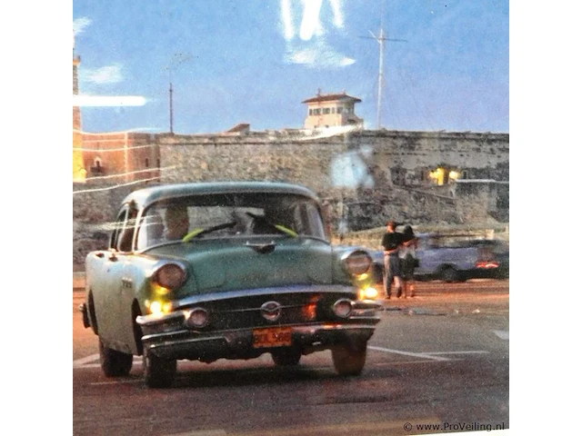 Ingelijste foto of poster getiteld "la habana" met een klassieke amerikaanse auto en de vuurtoren van het castillo de los tres reyes del morro in de achtergrond, gefotografeerd door guillermo bell in 2004 - afbeelding 3 van  5