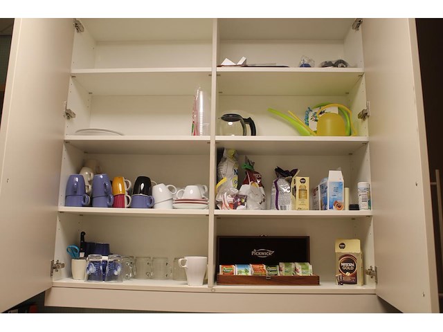 Inhoud keukenblok w.o. kopjes, bekers, thee, doeken en schoonmaakmiddelen. - afbeelding 1 van  5