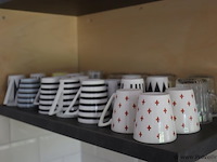 Inhoud keukenkastjes bestaande uit o.a. schoonmaakdoekjes, afwassponsjes, taartdoos, koffiebekers, snijplanken, borden & schalen - afbeelding 4 van  8
