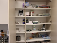Kantoormaterialen w.o. brievenbakjes, schrijfgerei, perforator, tissues, etc. in twee kasten en op schap.