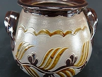 Keramieken pot met twee handvatten en een reliëfbladmotief in aardetinten, lijkend op traditioneel zoutgeglazuurd aardewerk uit west-duitsland (westerwald)