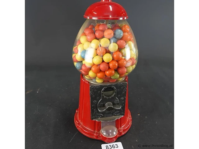 Klassieke rode retro kauwgomballenautomaat met een glazen bol en een metalen behuizing - afbeelding 1 van  6