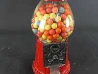 Klassieke rode retro kauwgomballenautomaat met een glazen bol en een metalen behuizing