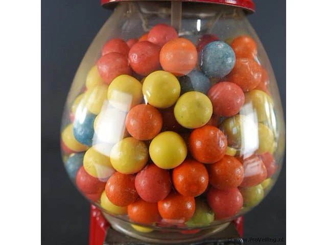 Klassieke rode retro kauwgomballenautomaat met een glazen bol en een metalen behuizing - afbeelding 4 van  6