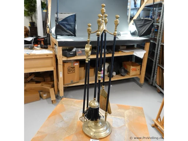Klassieke vintage haardset met een glimmende messing standaard en zwarte stelen - afbeelding 1 van  5