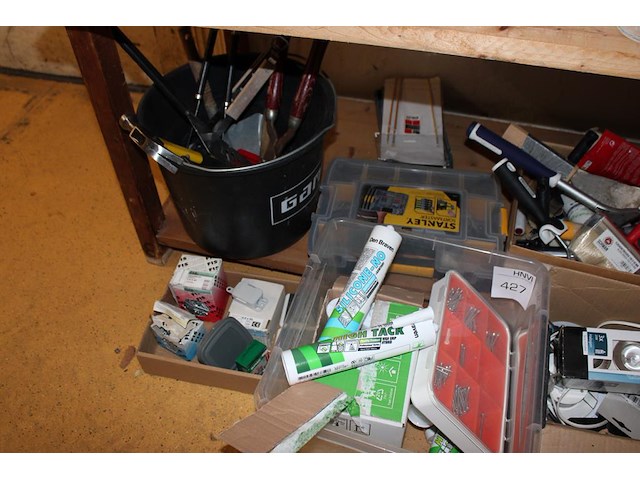 Klusproducten en gereedschappen op en voor schap. - afbeelding 2 van  3