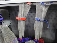 Krat met uitbeenschorten en uitbeenhandschoenen. totaal 10 schorten en 11 handschoenen - afbeelding 2 van  4