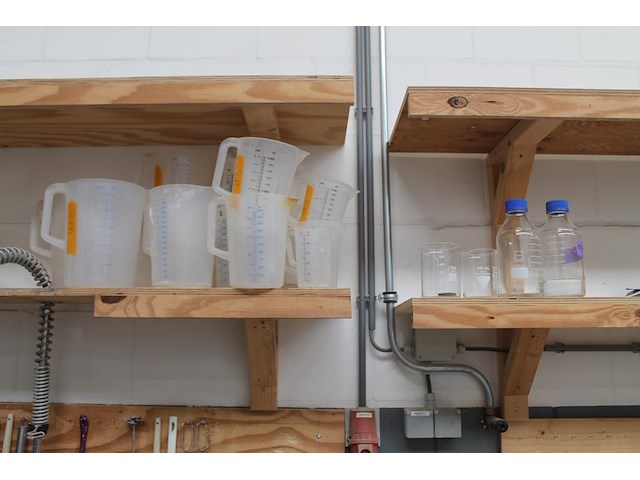 Laboratorium- en testproducten aan achterwand en op schap w.o. zeven, maatbekers, trechters, spanen, mengbe... - afbeelding 5 van  8