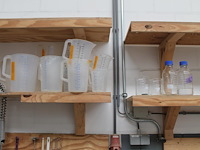 Laboratorium- en testproducten aan achterwand en op schap w.o. zeven, maatbekers, trechters, spanen, mengbe... - afbeelding 5 van  8