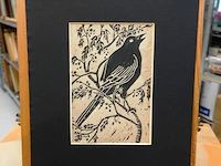 Linosnede of houtsnede op papier van een zangvogeltje (vermoedelijk een merel) dat op een tak zit - afbeelding 2 van  5