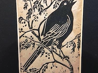 Linosnede of houtsnede op papier van een zangvogeltje (vermoedelijk een merel) dat op een tak zit - afbeelding 3 van  5