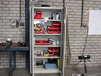Magazijnkast met 2 deuren gevuld met diverse gereedschappen, bevestigingsmaterialen en klusproducten.