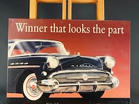 Metalen bord met een reproductie van een klassieke buick-autoadvertentie en de tekst "winner that looks the part"