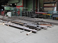 Metalen stripstaal, hoeklijnen en l-profielen op vloer en in rek.