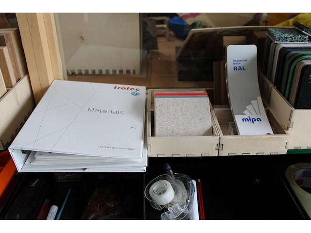 Monsters / stalen van diverse materialen w.o. vilt, kunststof en hout op glazen schappen. - afbeelding 3 van  4