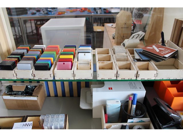 Monsters / stalen van diverse materialen w.o. vilt, kunststof en hout op glazen schappen. - afbeelding 4 van  4