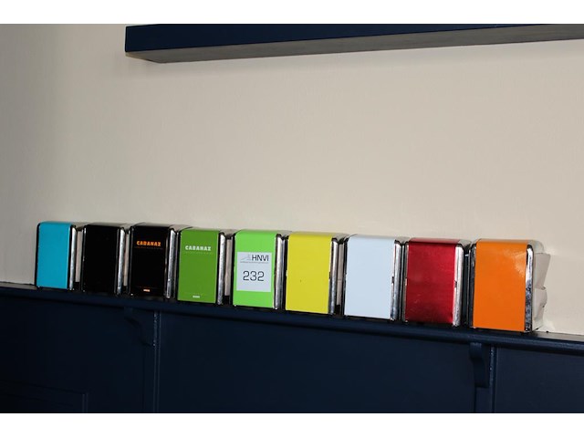 Negen gekleurde servethouders met doos servetten. - afbeelding 1 van  2