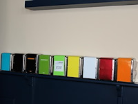 Negen gekleurde servethouders met doos servetten. - afbeelding 1 van  2