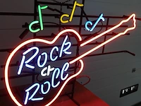 Neonreclame in de vorm van een elektrische gitaar met de tekst "rock & roll" en muzieknoten. werkend - afbeelding 4 van  7