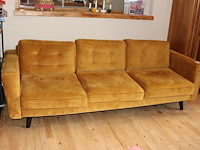 Okerkleurige driezitsbank met afmeting 240 x 100 x 80 cm.