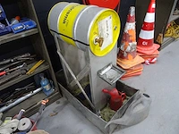 Olievat op metalen stelling met lekbak
