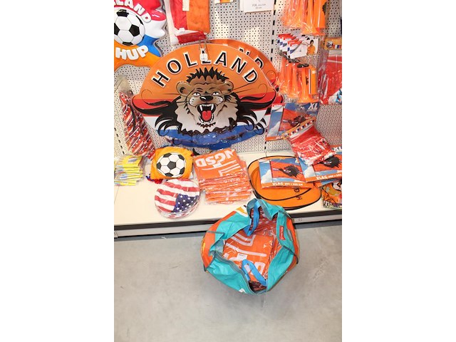 Oranje decoratie aan twee wandschappen w.o. vlaggen, borden, toeters, tassen, slingers en buttons. - afbeelding 5 van  5