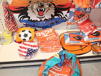 Oranje decoratie aan twee wandschappen w.o. vlaggen, borden, toeters, tassen, slingers en buttons. - afbeelding 5 van  5