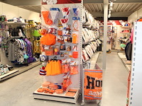 Oranje producten op kopstelling en in winkelmand w.o. vlaggen, caps, mutsen, toeters, servies en brillen. - afbeelding 1 van  2