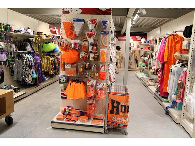 Oranje producten op kopstelling en in winkelmand w.o. vlaggen, caps, mutsen, toeters, servies en brillen. - afbeelding 1 van  5