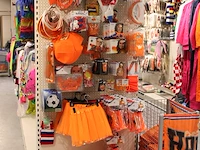 Oranje producten op kopstelling en in winkelmand w.o. vlaggen, caps, mutsen, toeters, servies en brillen. - afbeelding 2 van  5