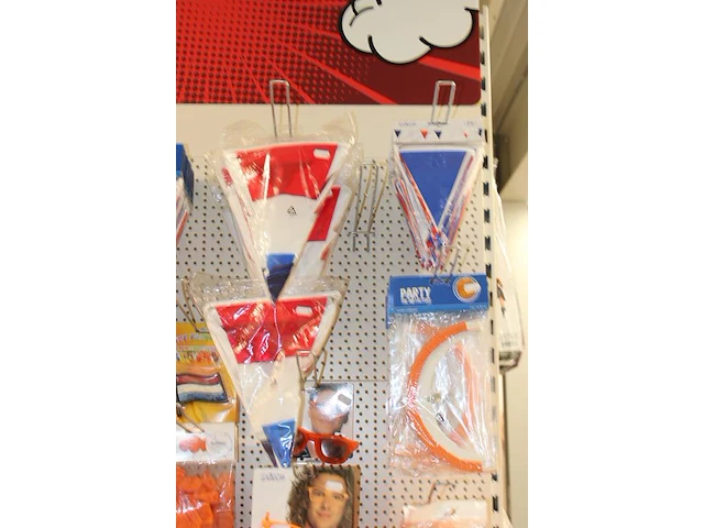 Oranje producten op kopstelling en in winkelmand w.o. vlaggen, caps, mutsen, toeters, servies en brillen. - afbeelding 3 van  5