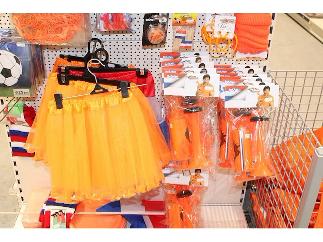 Oranje producten op kopstelling en in winkelmand w.o. vlaggen, caps, mutsen, toeters, servies en brillen. - afbeelding 4 van  5