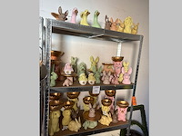 Paasproducten op drie schappen w.o. konijnen, kuikens en ganzen. - afbeelding 1 van  2