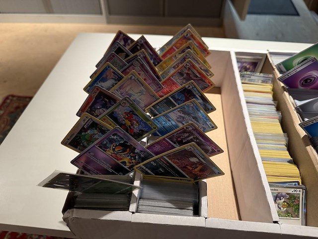 Pokemon producten op drie stellingschappen w.o. pokemon kaarten, pins pokemon blikken, pokemon verzamelmapp... onderdeel van combinatiekavel kavels p001 t/m p051 combinatiekavel - afbeelding 3 van  15