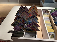 Pokemon producten op drie stellingschappen w.o. pokemon kaarten, pins pokemon blikken, pokemon verzamelmapp... onderdeel van combinatiekavel kavels p001 t/m p051 combinatiekavel - afbeelding 3 van  15