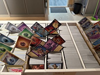 Pokemon producten op drie stellingschappen w.o. pokemon kaarten, pins pokemon blikken, pokemon verzamelmapp... onderdeel van combinatiekavel kavels p001 t/m p051 combinatiekavel - afbeelding 5 van  15