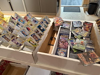 Pokemon producten op drie stellingschappen w.o. verzamelmappen, metalen koffertjes, puzzles, beschermzakjes... onderdeel van combinatiekavel kavels p001 t/m p051 combinatiekavel - afbeelding 6 van  18