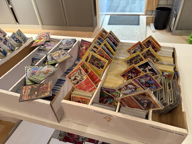 Pokemon producten op drie stellingschappen w.o. verzamelmappen, metalen koffertjes, puzzles, beschermzakjes... onderdeel van combinatiekavel kavels p001 t/m p051 combinatiekavel - afbeelding 7 van  18