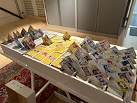 Pokemon producten op drie stellingschappen w.o. verzamelmappen, metalen koffertjes, puzzles, beschermzakjes... onderdeel van combinatiekavel kavels p001 t/m p051 combinatiekavel - afbeelding 8 van  18