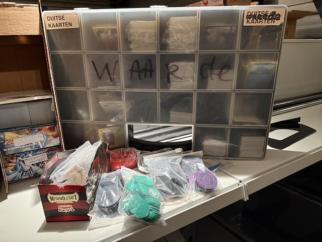 Pokemon producten op drie stellingschappen w.o. verzamelmappen, metalen koffertjes, puzzles, beschermzakjes... onderdeel van combinatiekavel kavels p001 t/m p051 combinatiekavel - afbeelding 12 van  18