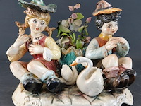 Porseleinen capodimonte beeldje van een jong stel omringd door zwanen, handbeschilderd in pastelkleuren - afbeelding 1 van  5