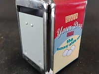 Retro servettendispenser met een jaren 50-stijl en een opdruk met eieren en de tekst "begin your day the sunny side up"