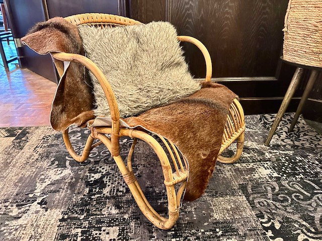 Rotan fauteuil met koeienhuid en kussen - afbeelding 1 van  3