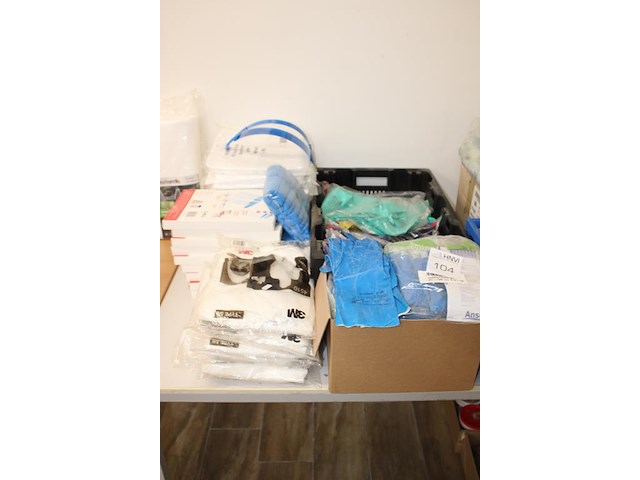 Schoonmaakprodukten w.o. handschoenen, schoenencovers, wegwerpoverals en gezichtskappen op tafel. - afbeelding 2 van  3