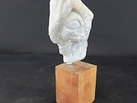 Stenen sculptuur op houten basement - afbeelding 1 van  5