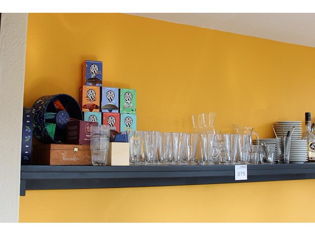 Theeproducten waaronder glazen, onderzetters en thee op schap. - afbeelding 1 van  2